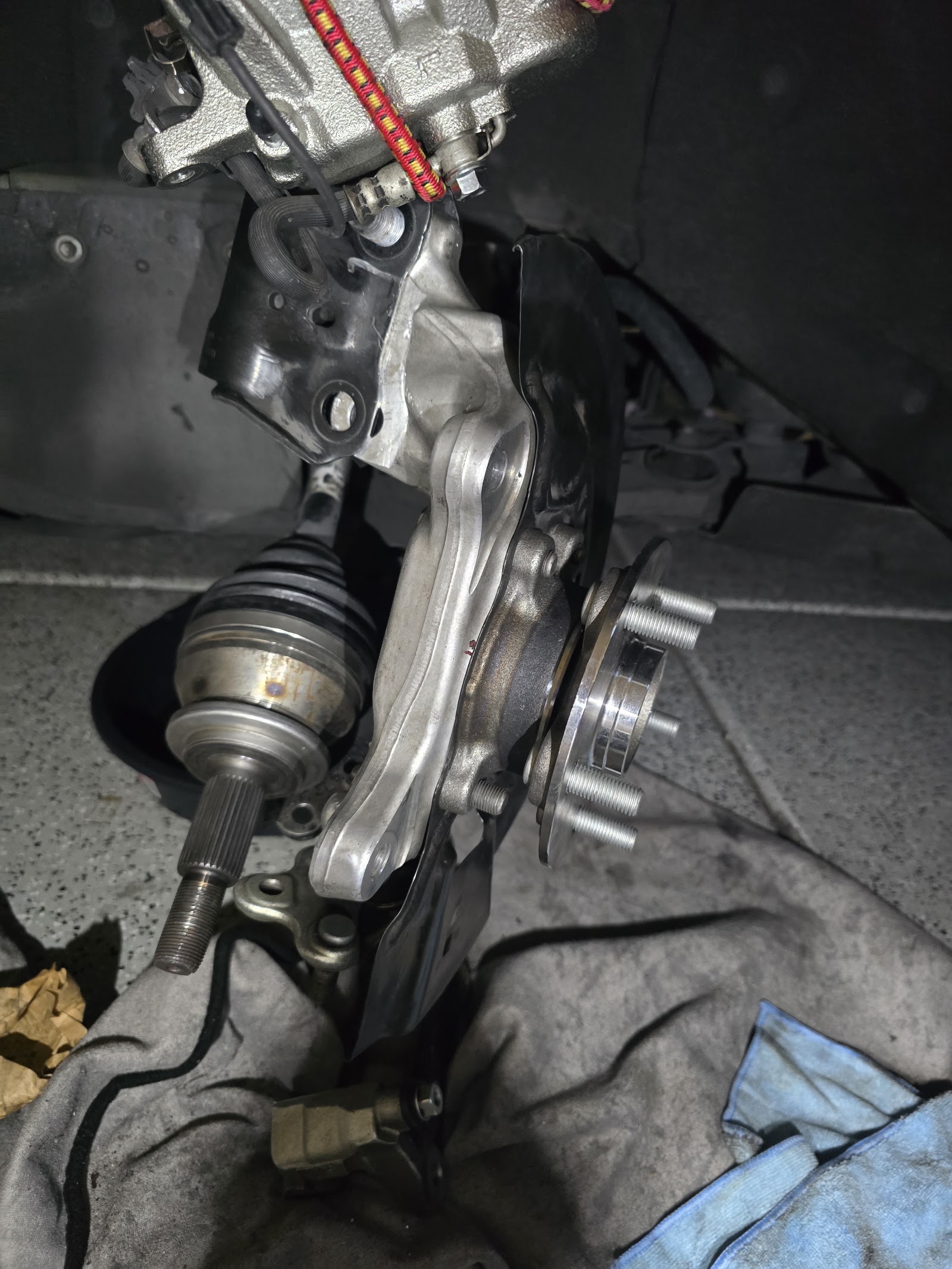 Front suspension knuckle, CV axle, and wheel hub exposed during repair