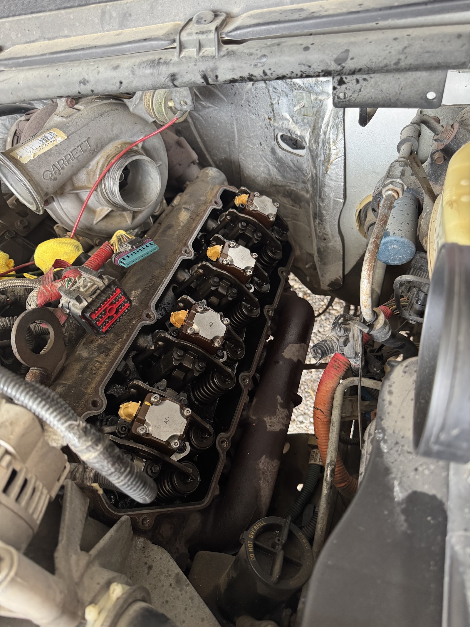 Diesel engine with Garrett turbo and valve cover removed showing fuel injectors