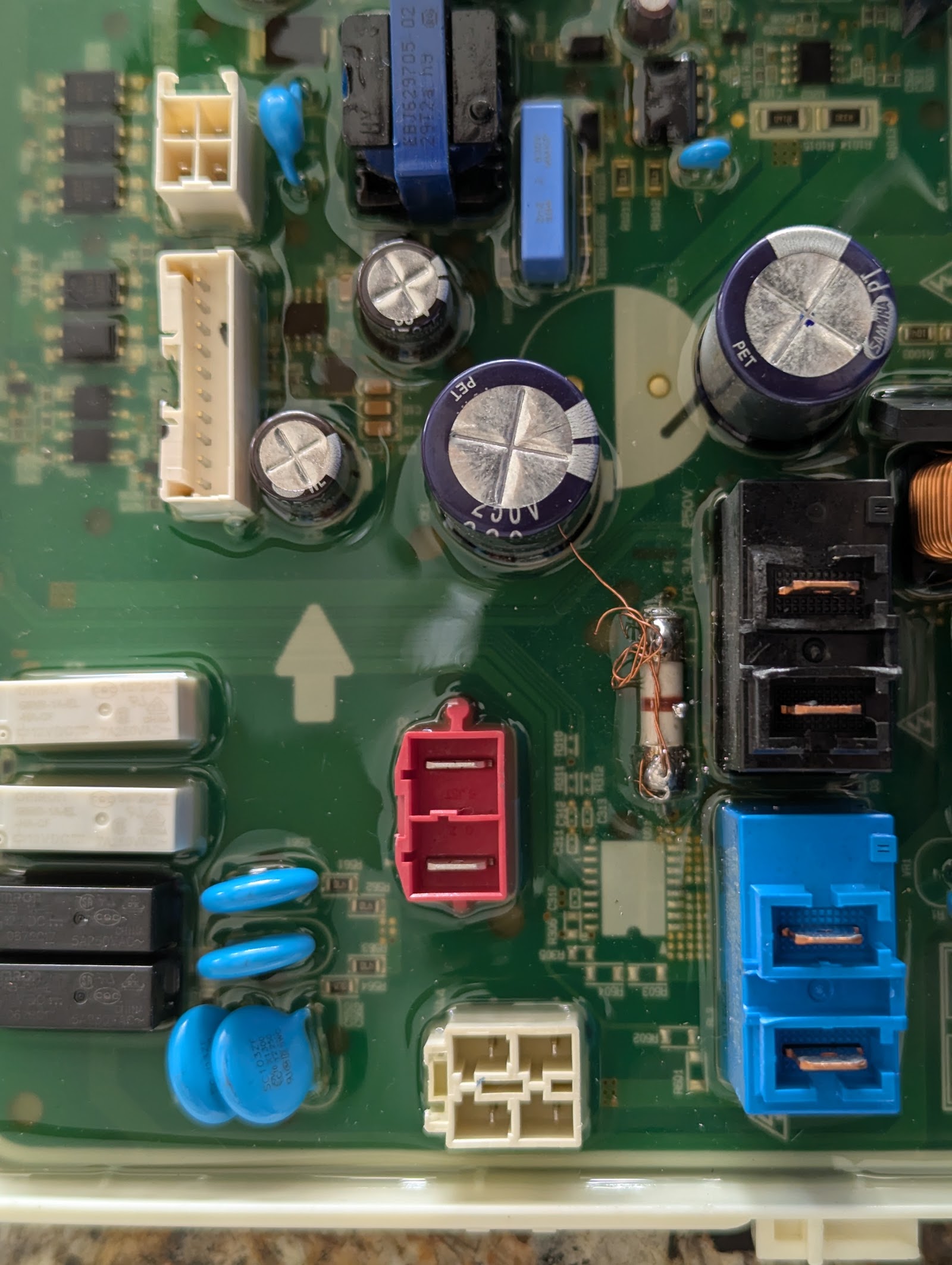 Close-up of appliance control board with capacitors and connectors
