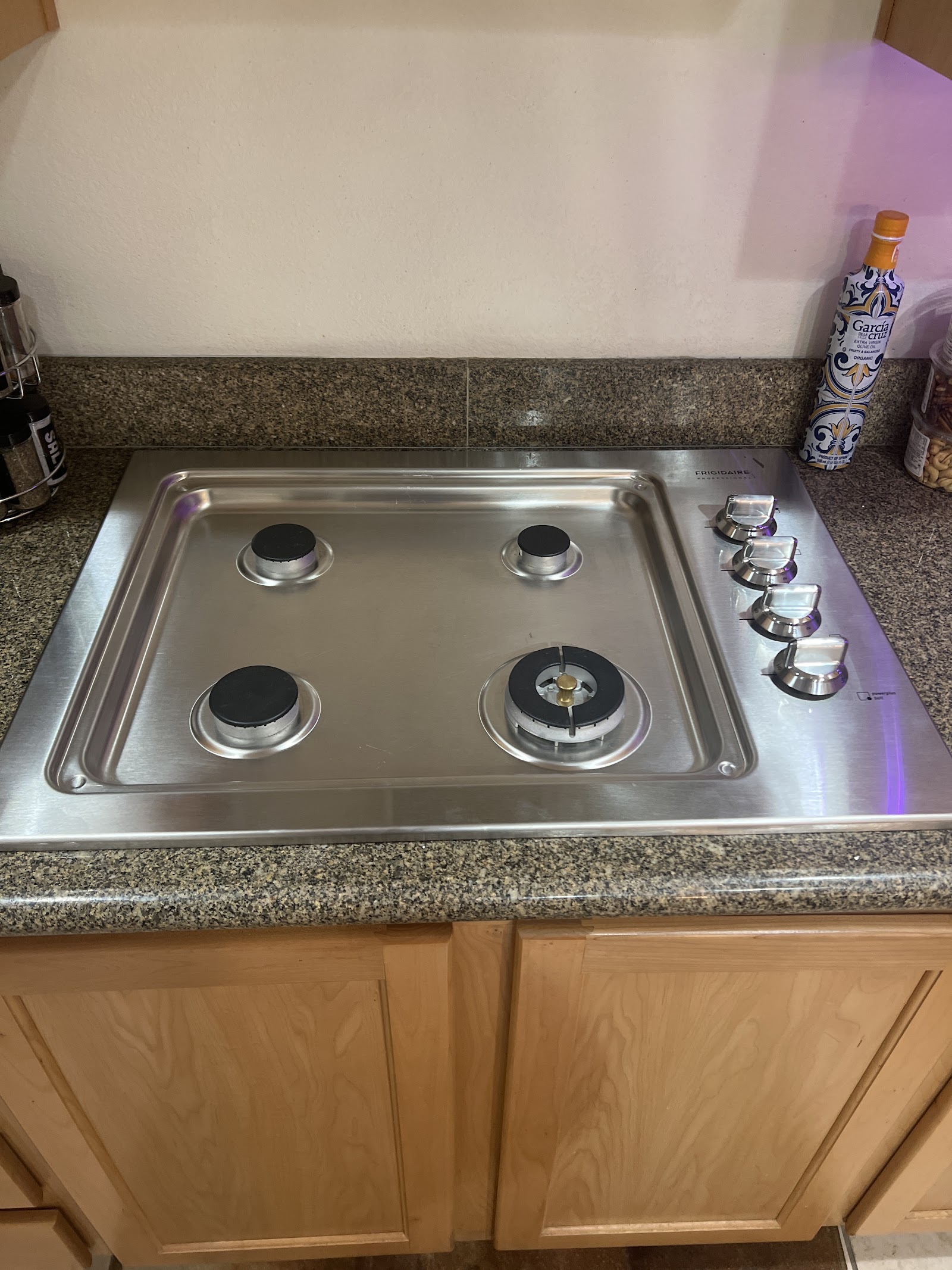 Stainless steel Frigidaire Professional 4-burner gas cooktop installed in granite counter