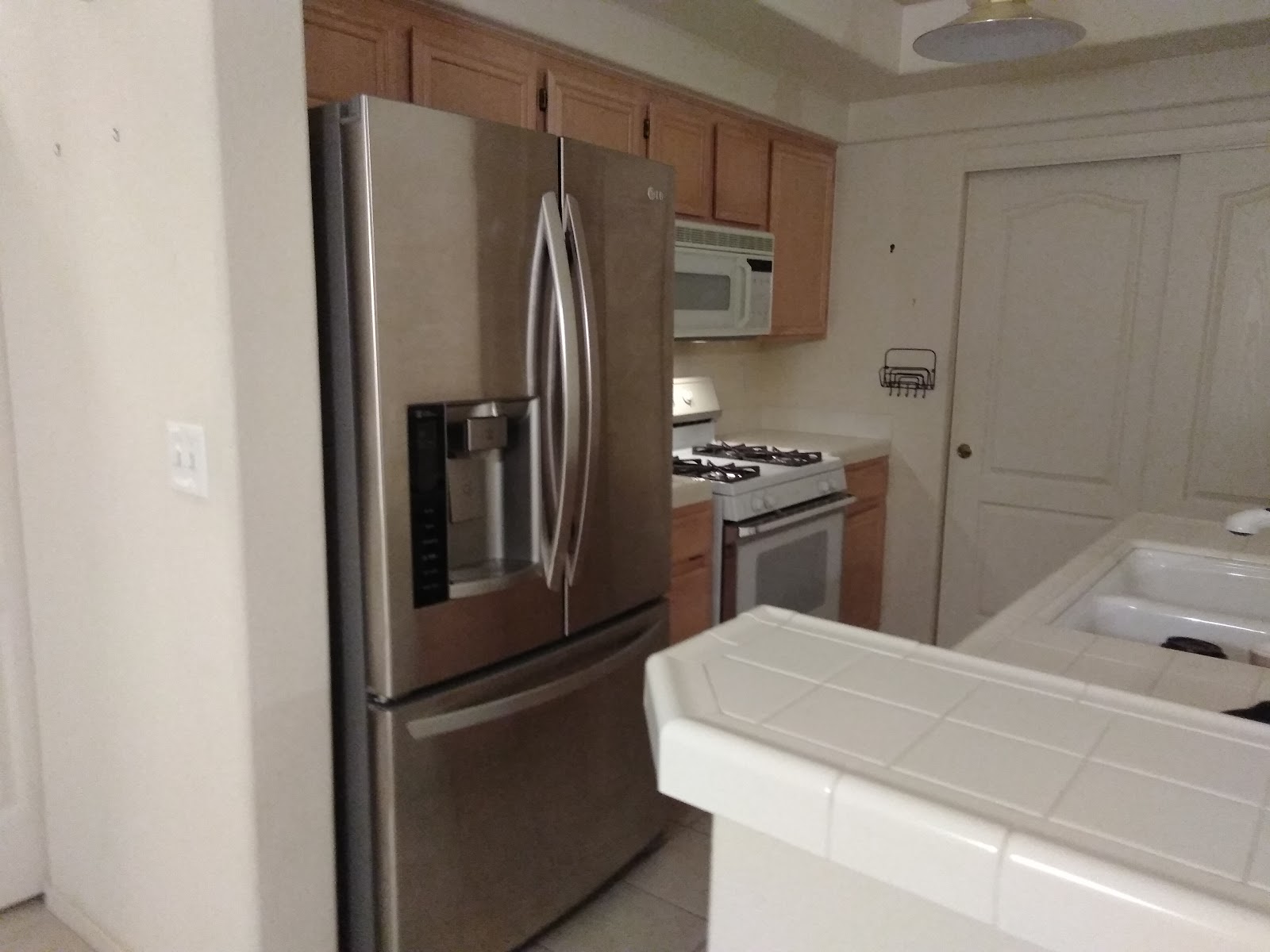 Kitchen with stainless LG French-door fridge and white gas range