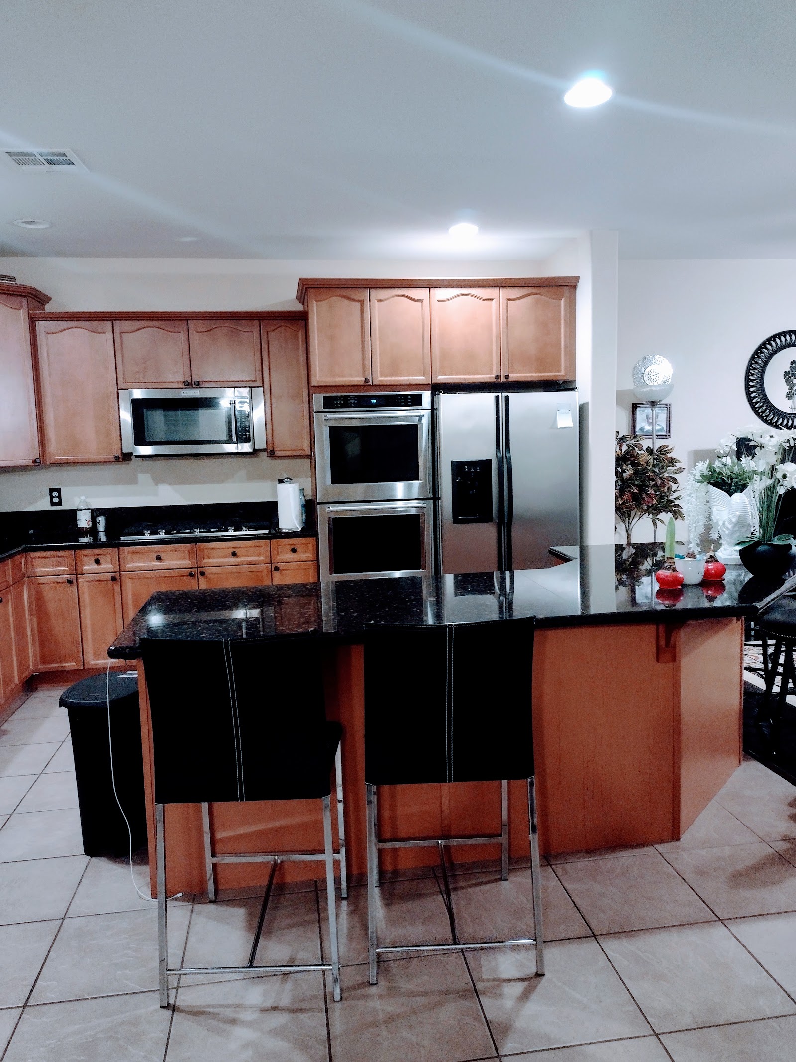 Clean kitchen with wood cabinets, granite island and bar stools