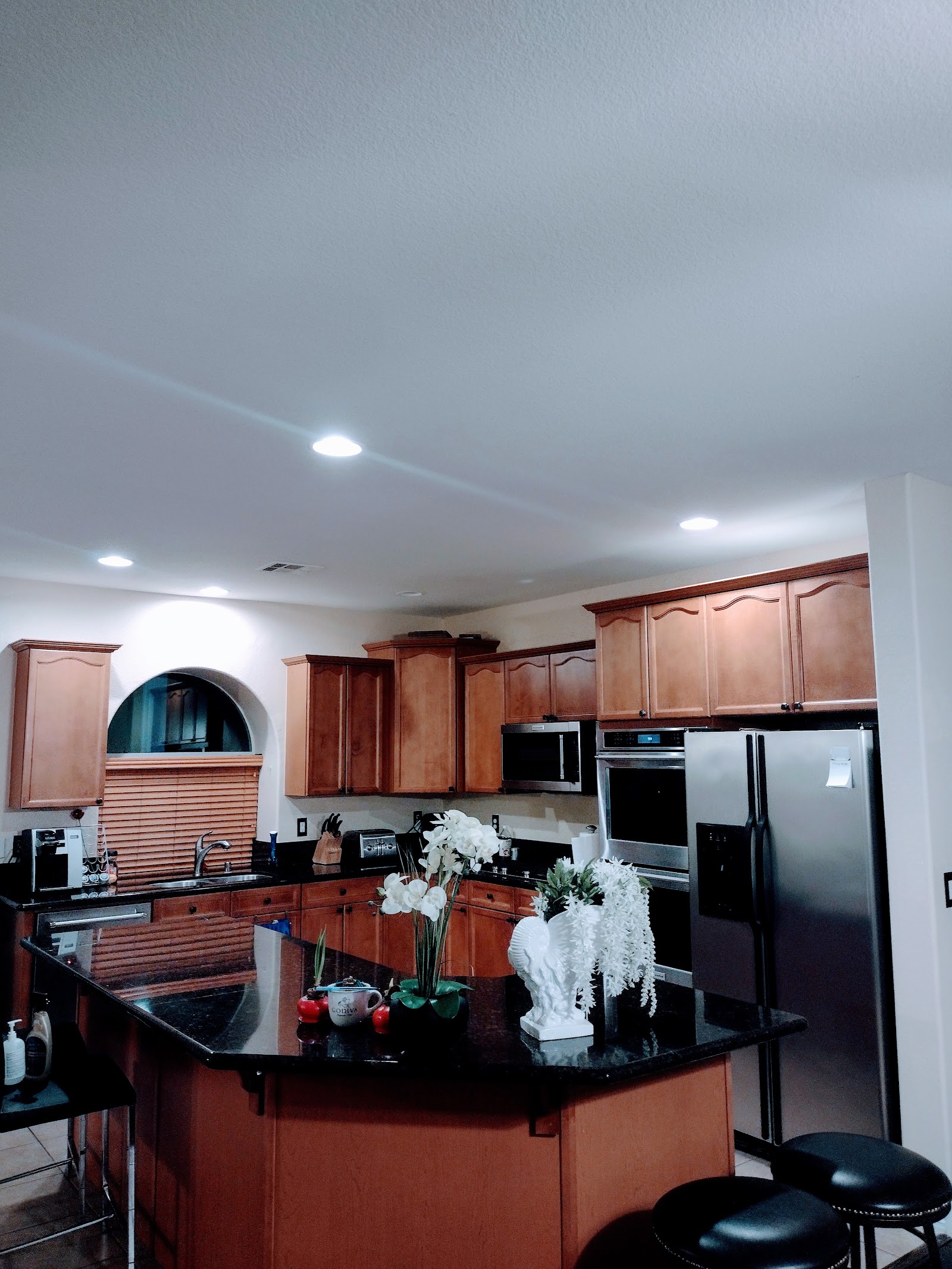 Kitchen with wood cabinets, stainless appliances and decorated island
