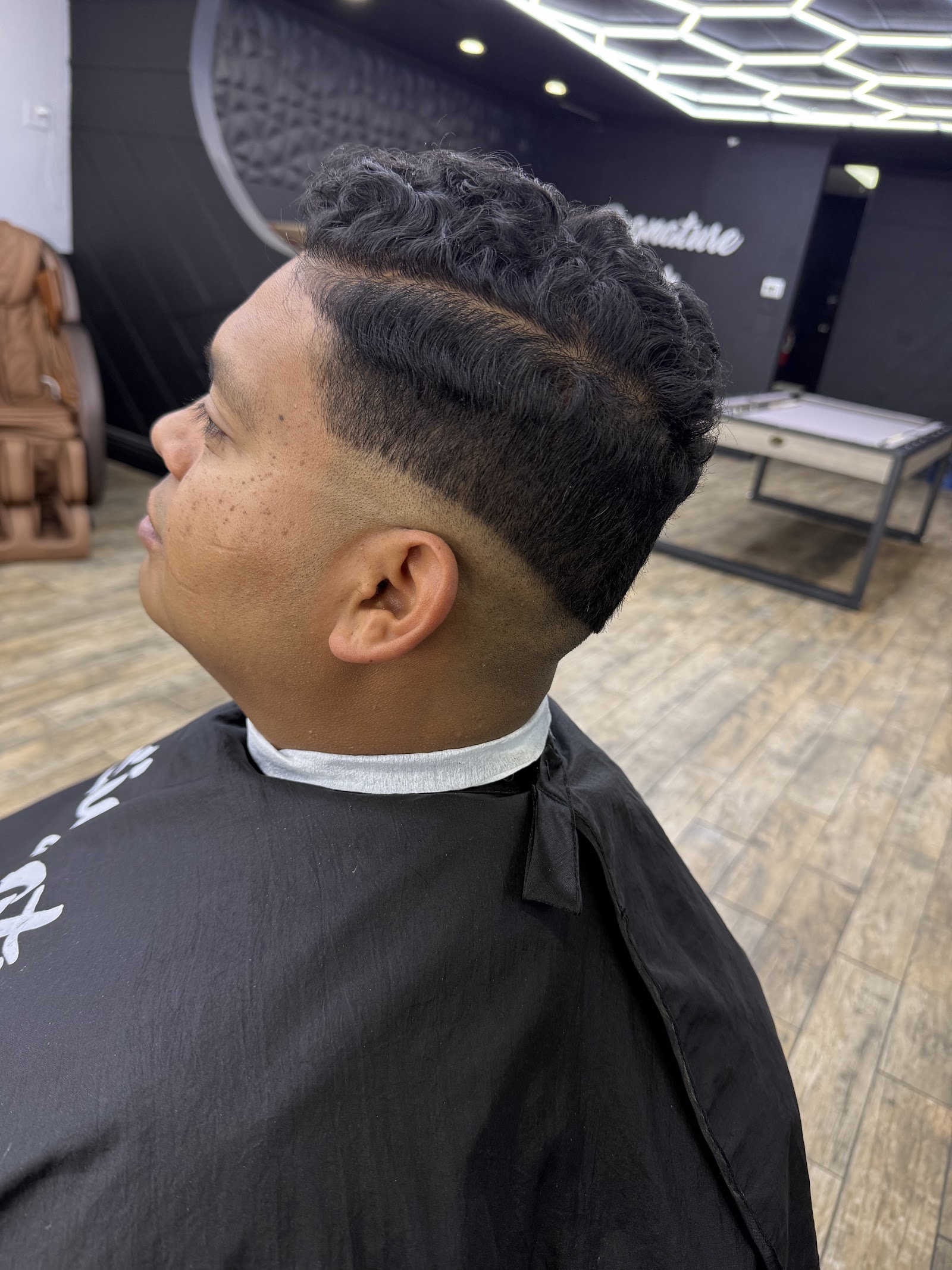 Side profile of a wavy textured taper fade haircut in the barbershop