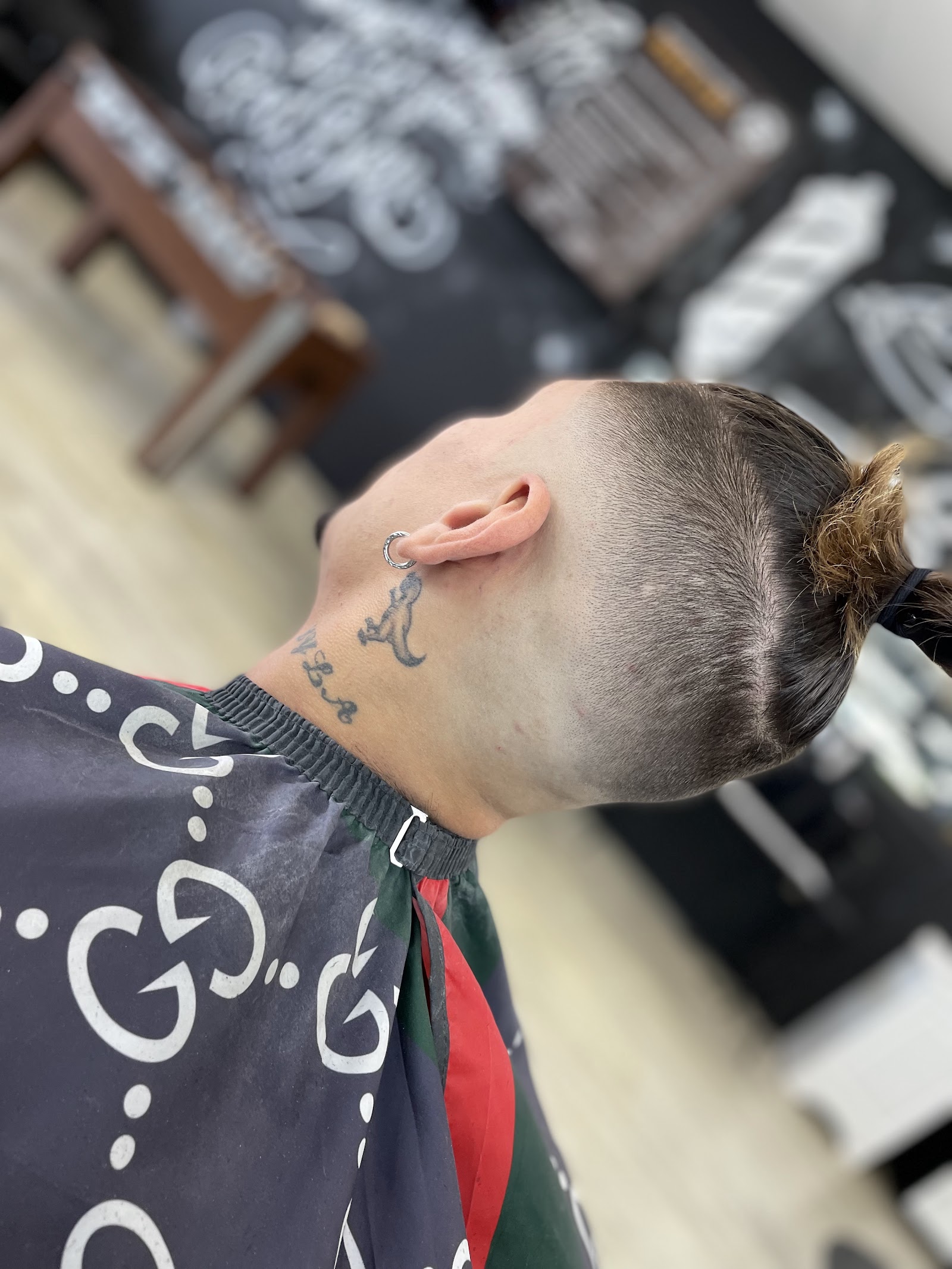 Overhead angle of client with high fade and small ponytail