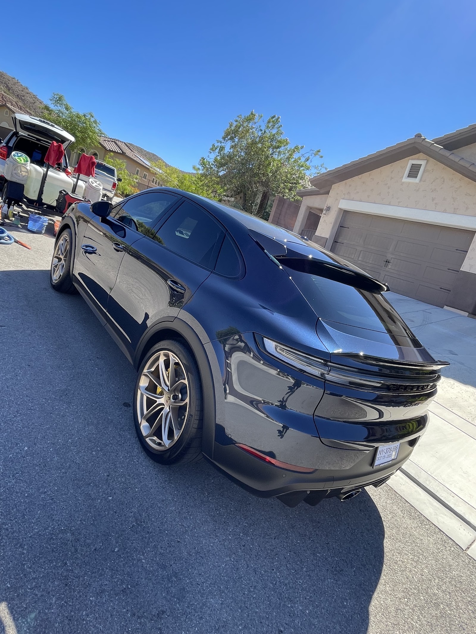Detailed black Porsche Cayenne coupe glossy rear-quarter view in driveway