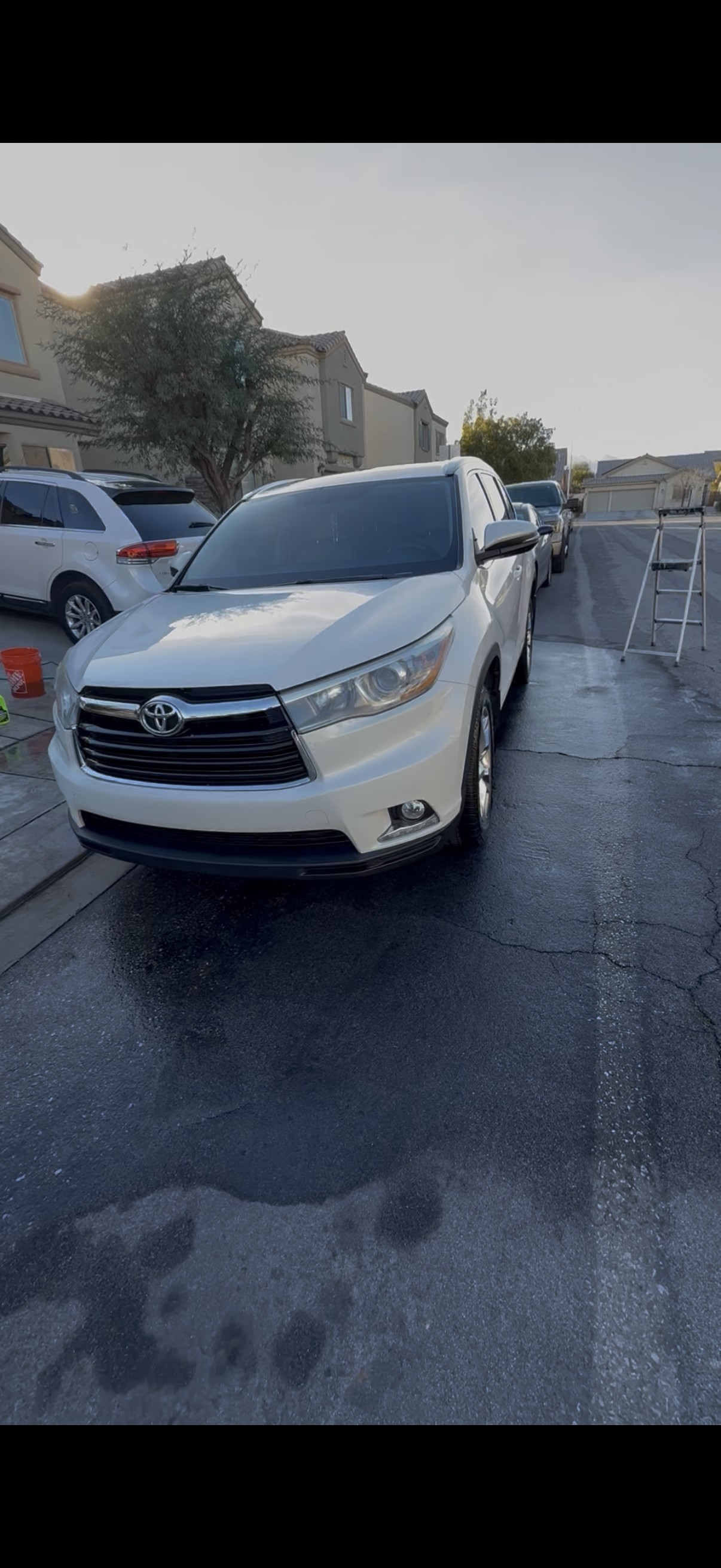 White Toyota Highlander freshly washed on wet driveway