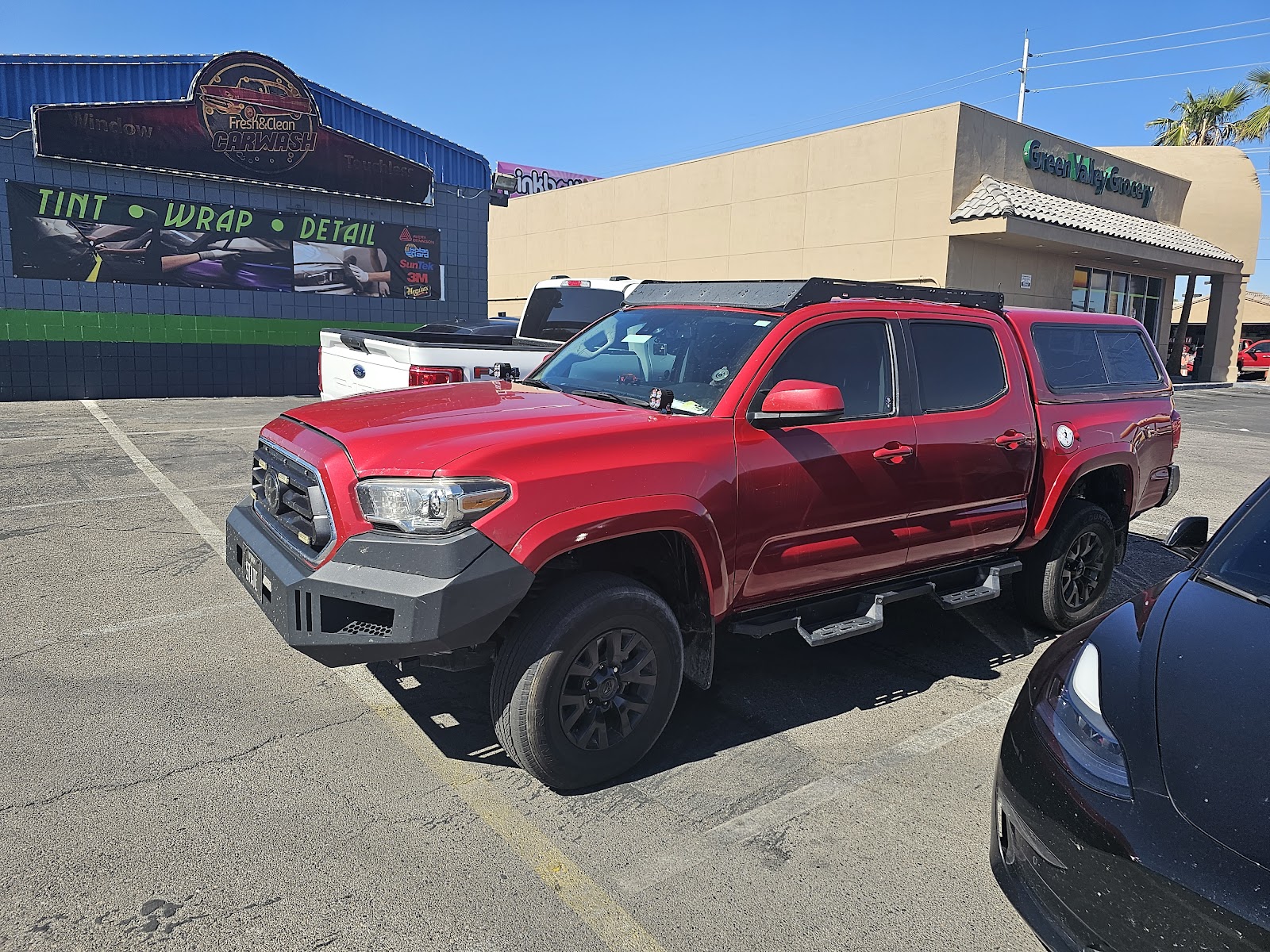 Red Toyota Tacoma outside Fresh & Clean Carwash with Tint Wrap Detail banner