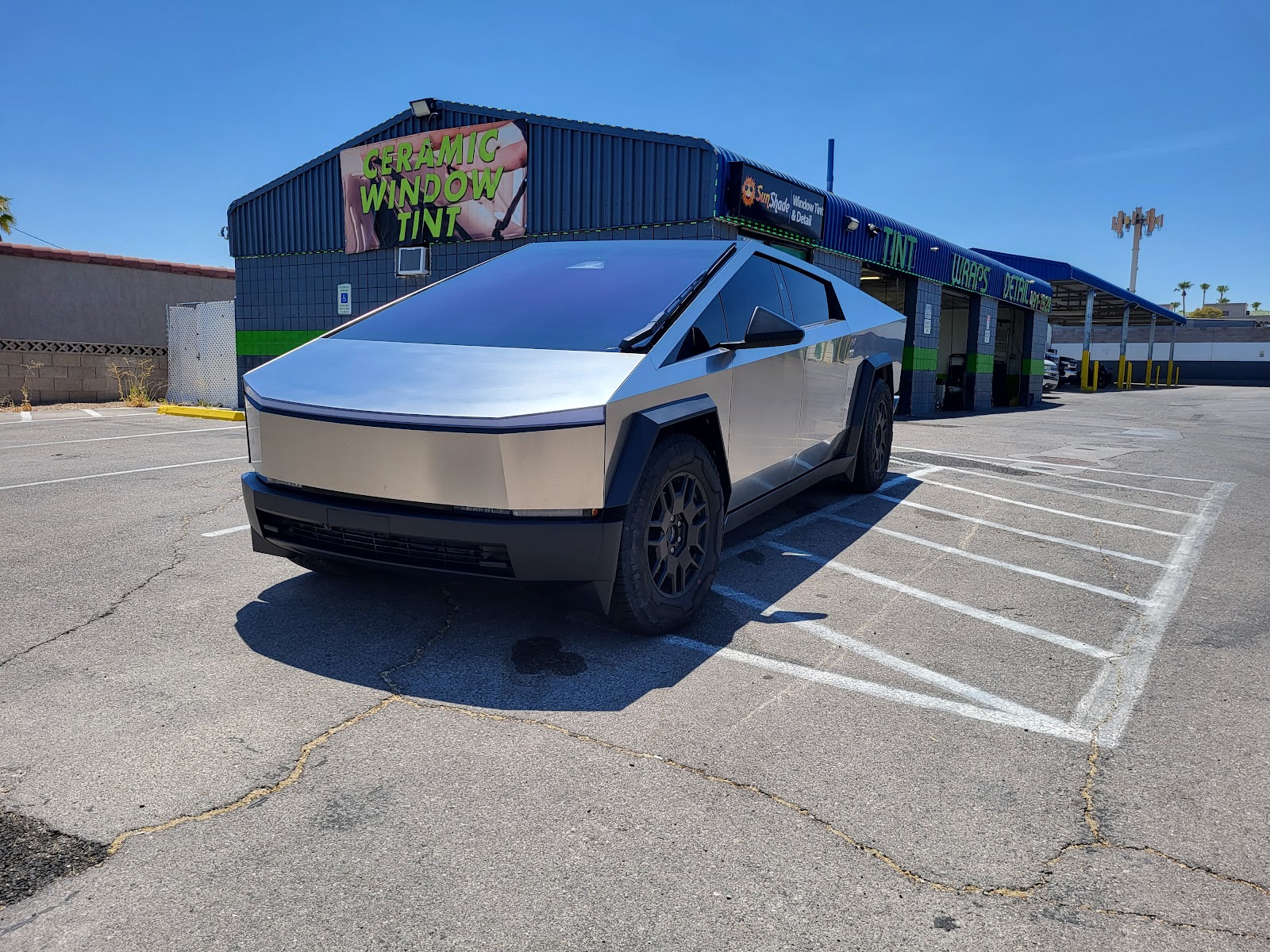 Tesla Cybertruck parked in front of shop with Ceramic Window Tint sign