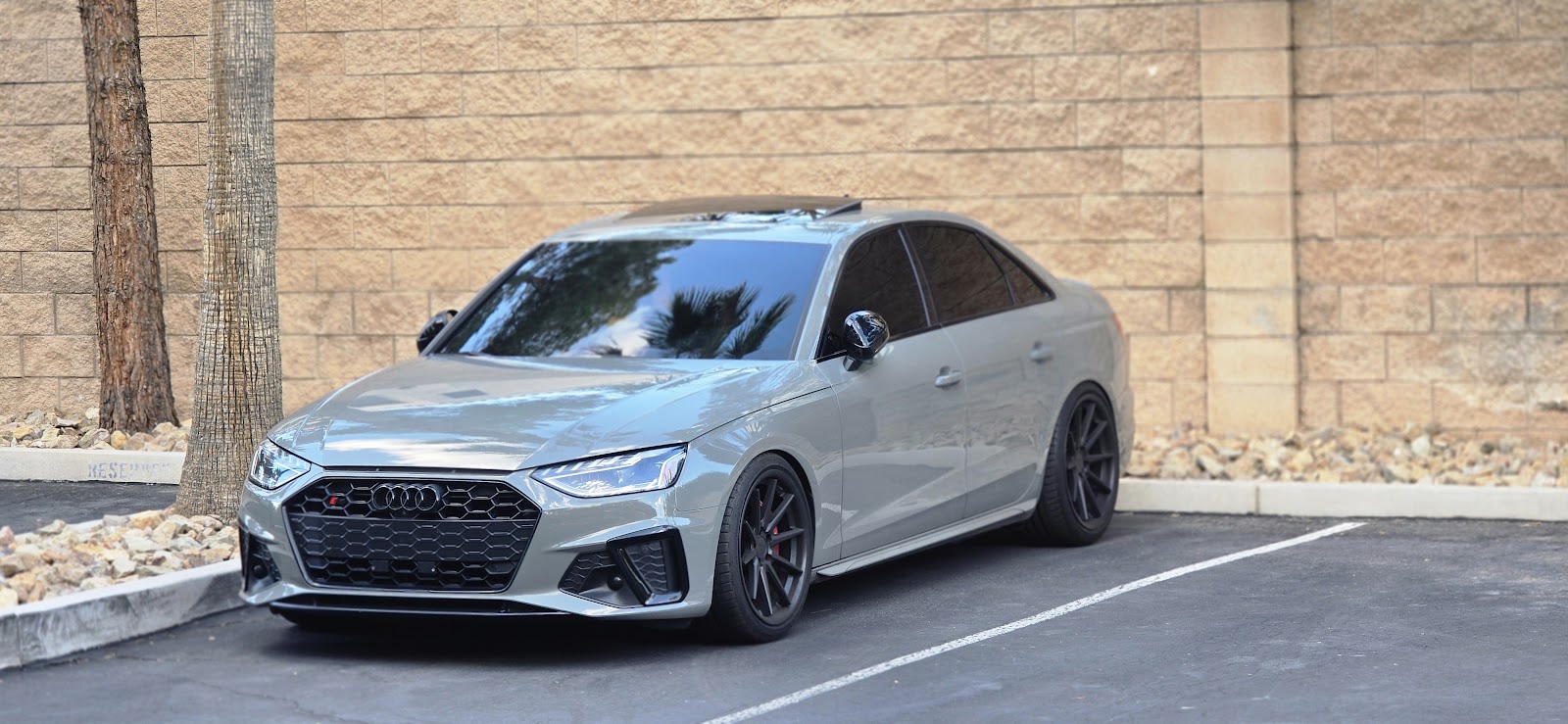 Nardo gray Audi S4 with tinted windows against block wall