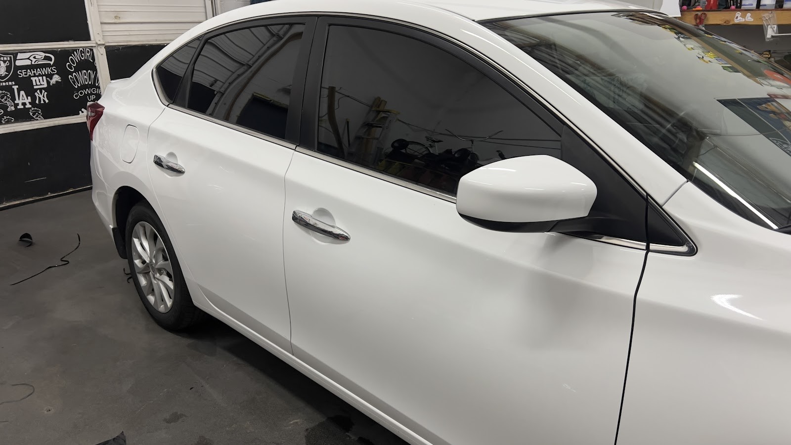 White Nissan Sentra with tinted windows in tint shop