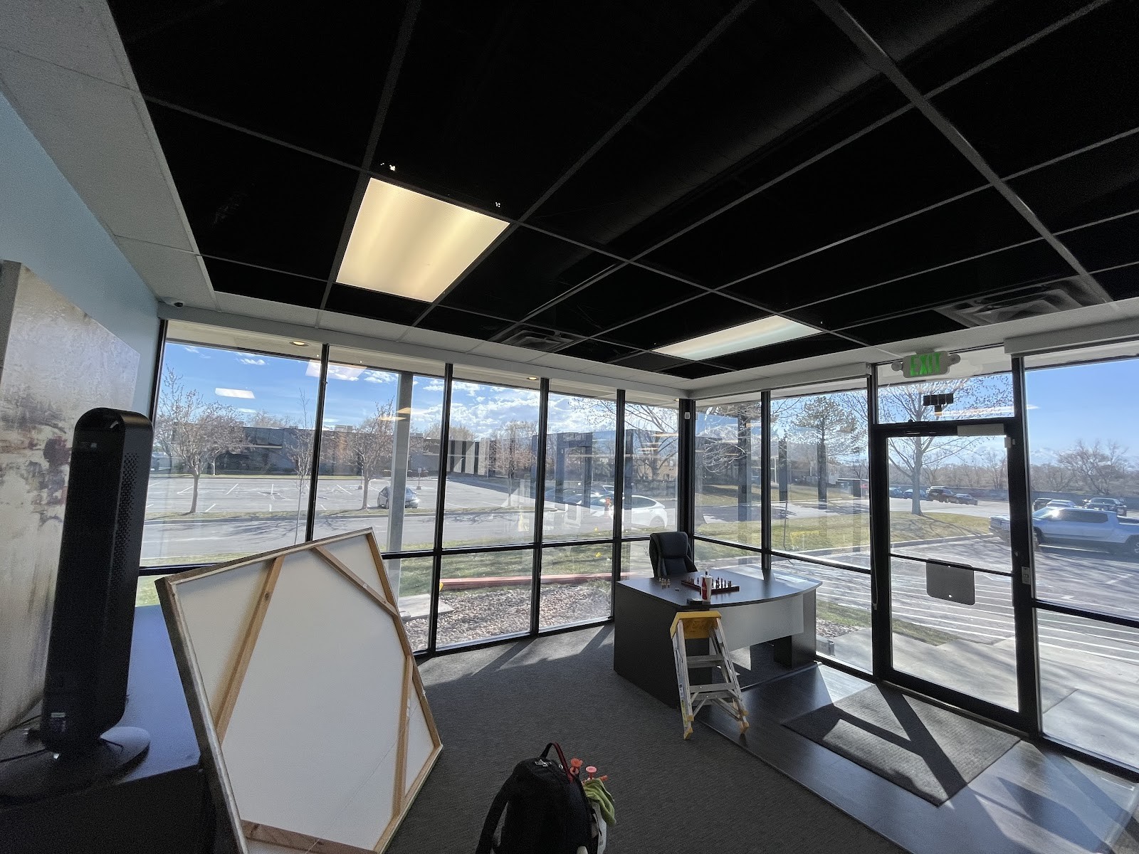Commercial office with floor-to-ceiling tinted windows and parking lot view