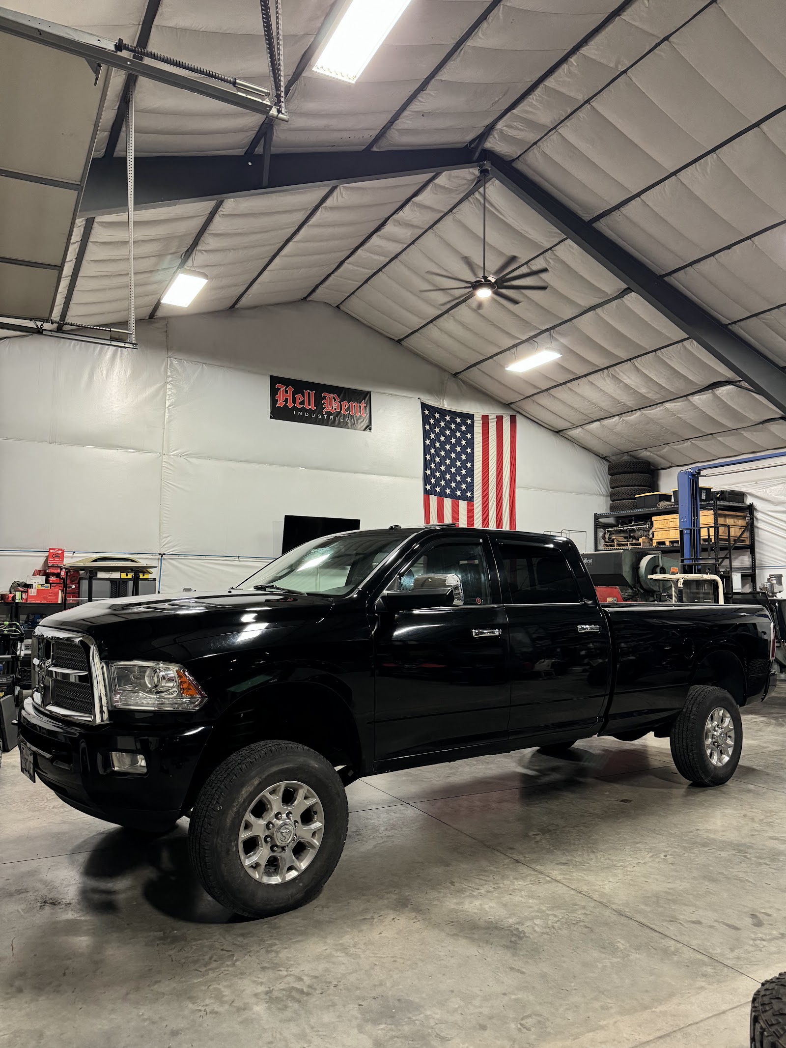 Black Ram pickup truck with tinted windows in a shop with American flag