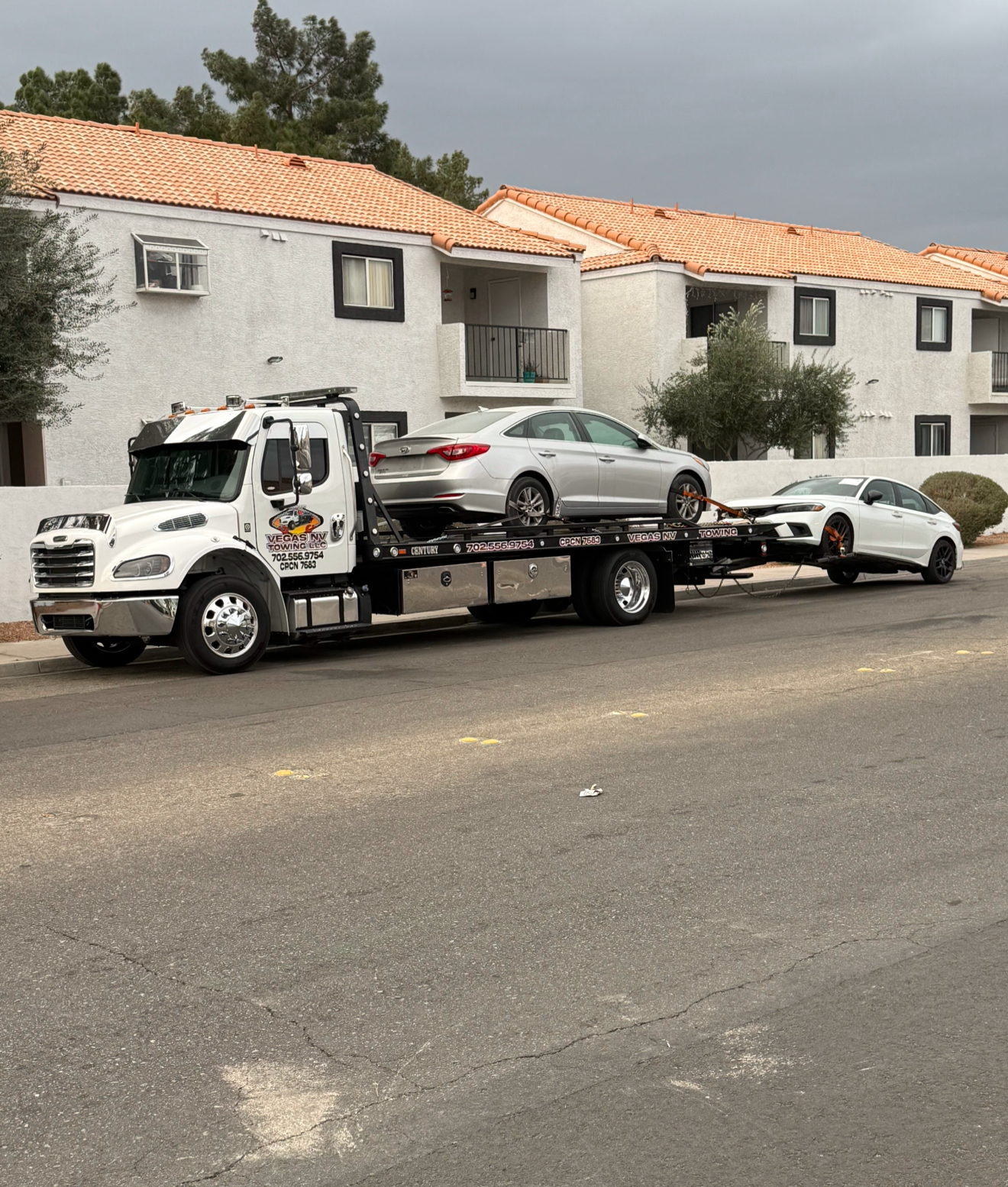 Silver Hyundai Sonata on a Vegas NV Towing flatbed towing a white sedan behind