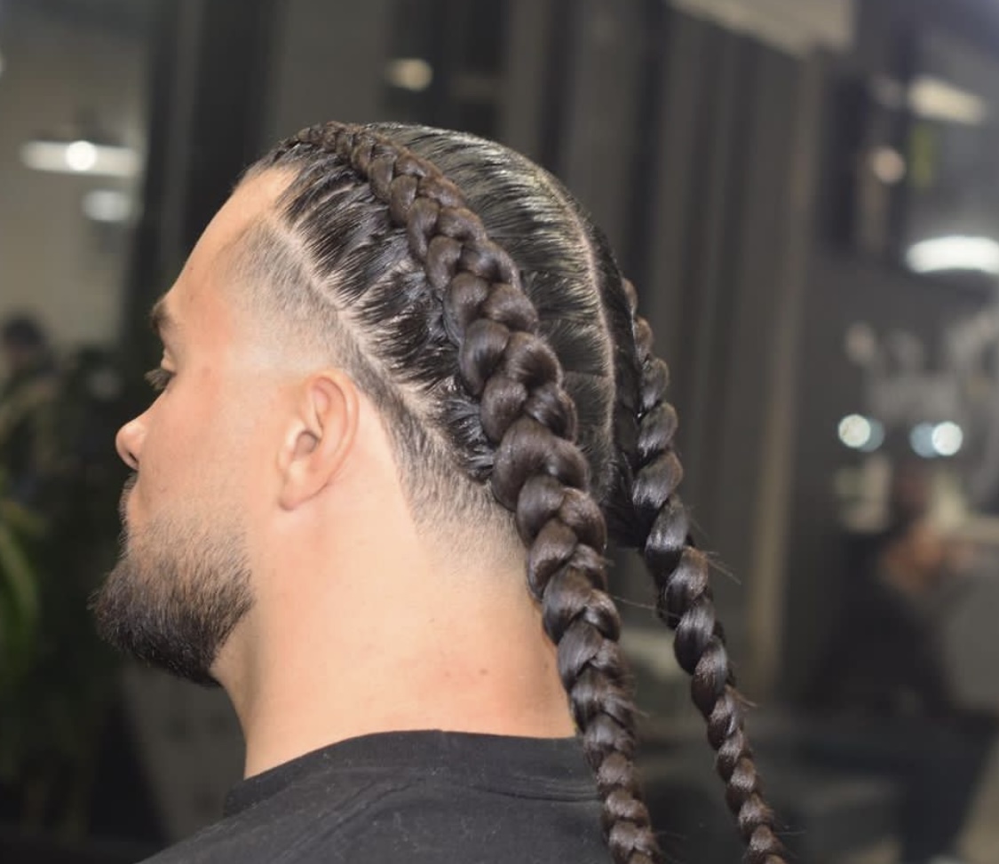 Men's two-braid cornrow style with faded sides and beard