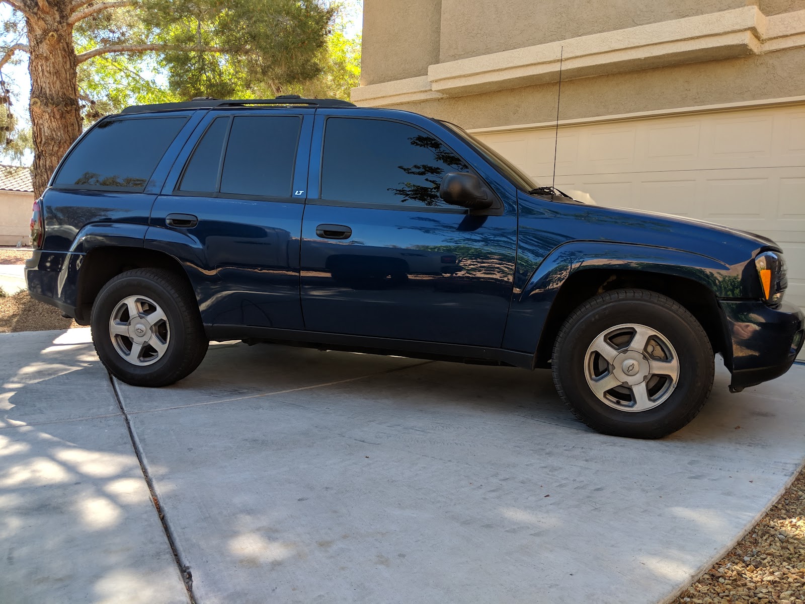Blue Chevrolet TrailBlazer SUV with tinted windows in driveway