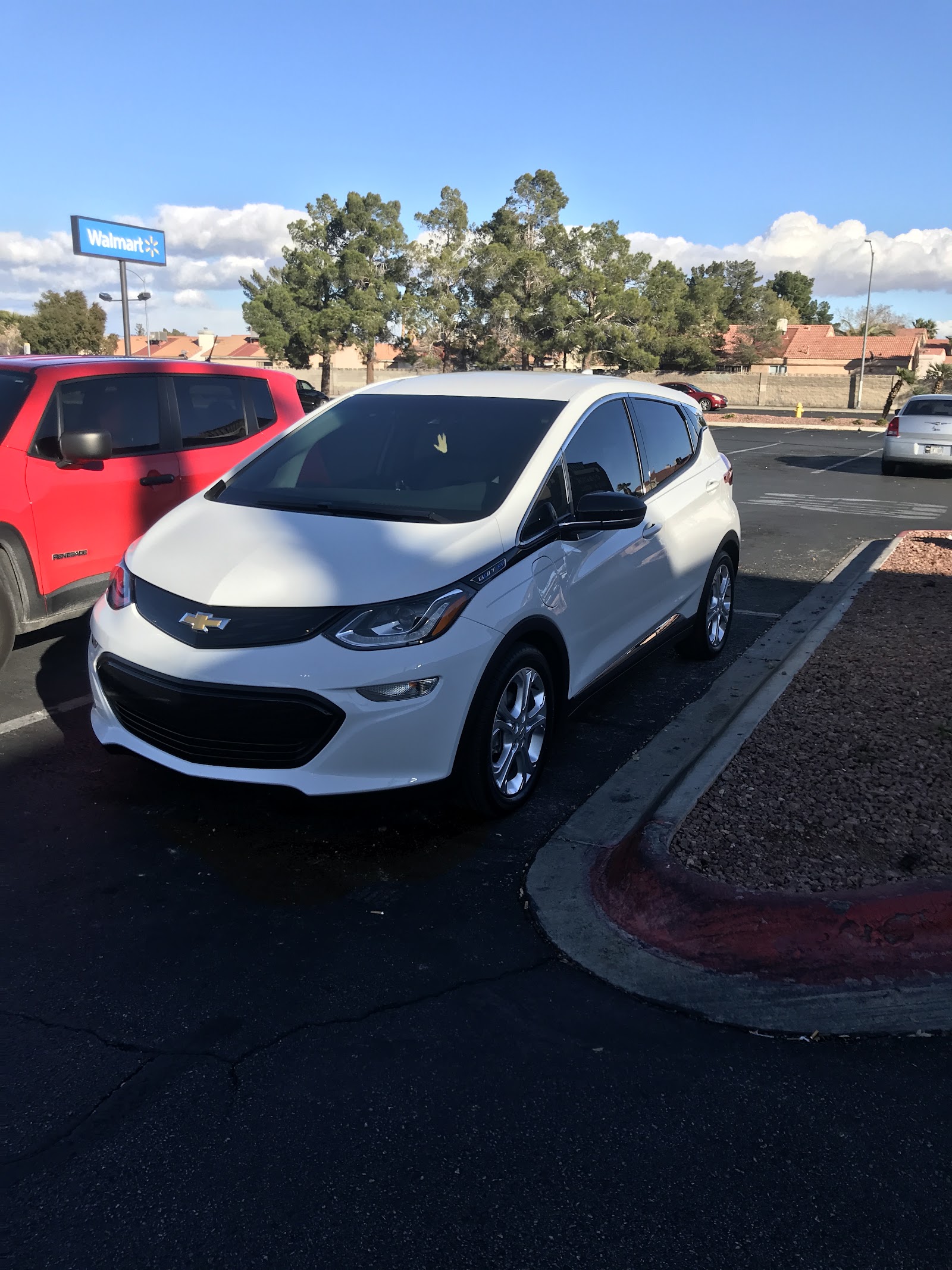 White Chevrolet Bolt EV with tinted windows in a parking lot