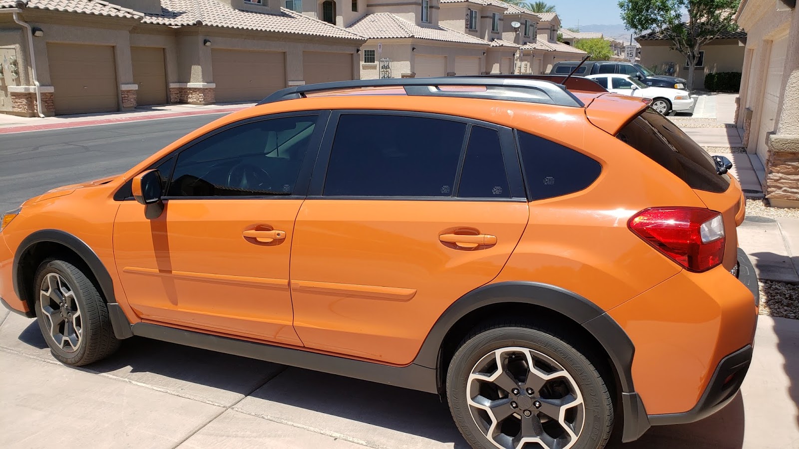 Orange Subaru Crosstrek with tinted windows parked on driveway