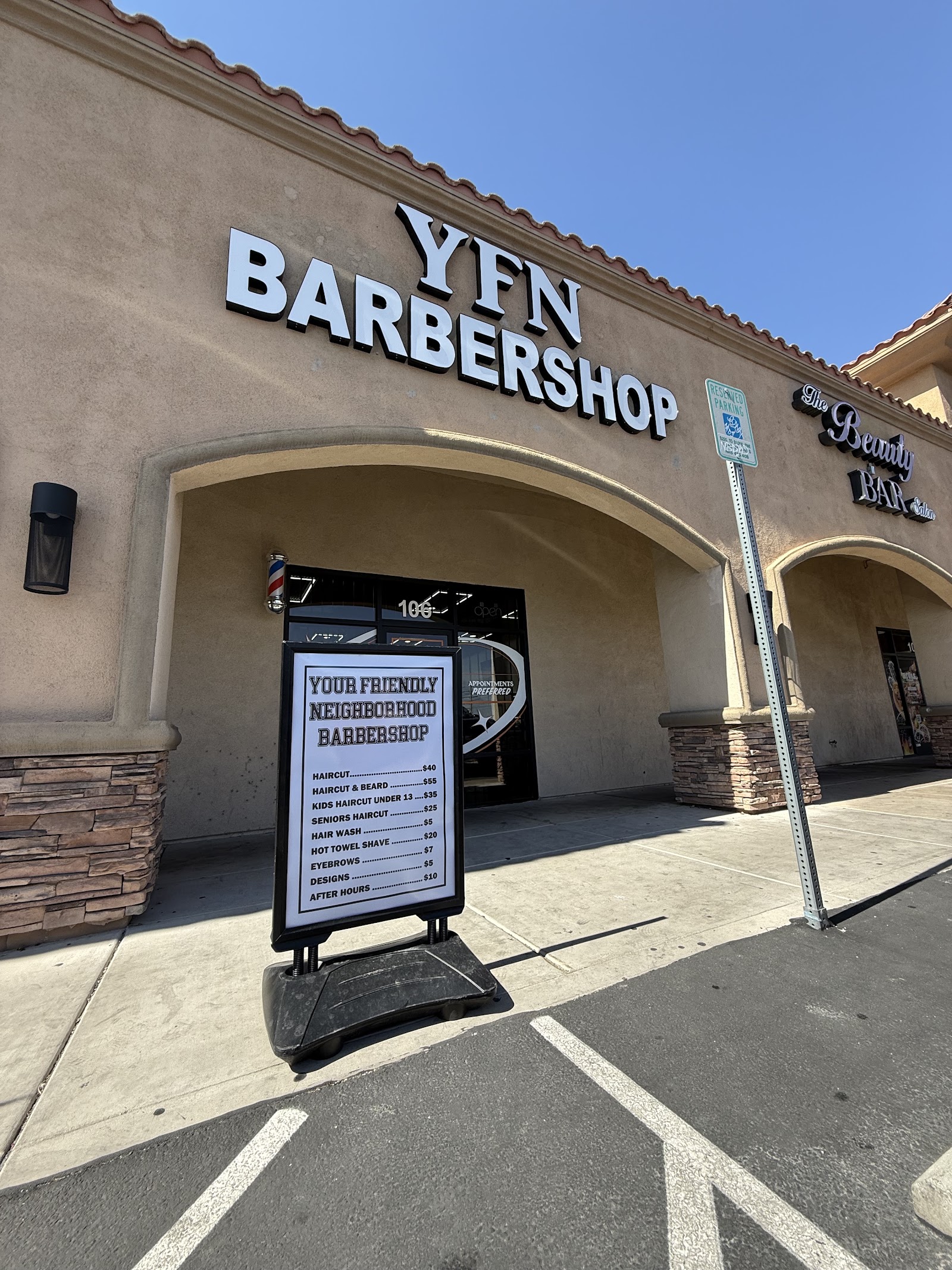Exterior storefront of YFN Barbershop with signage and sidewalk price board
